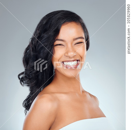 Shes absolutely gorgeous. Studio portrait of an attractive young woman posing against a grey background. 105829960