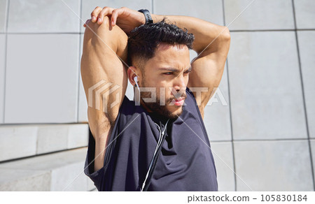 Every efforts add up to something. Shot of a sporty young man listening to music and stretching his arms while exercising outdoors. 105830184