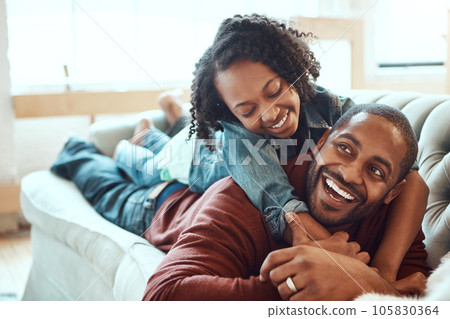 Black family, love and father with girl on sofa enjoying quality time, bonding and relax together on weekend. Living room, happiness and daughter embrace, hugging and laying with dad on couch at home 105830364