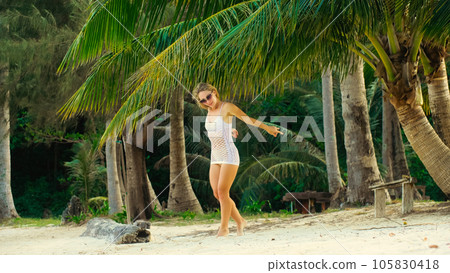 The tanned woman dances cool and appetizing on the beach of Koh Chang island in Thailand. Booty dancing twerk. Concept travel, walks, rest in sea, tropical resort traveling tourism summer holidays 105830418
