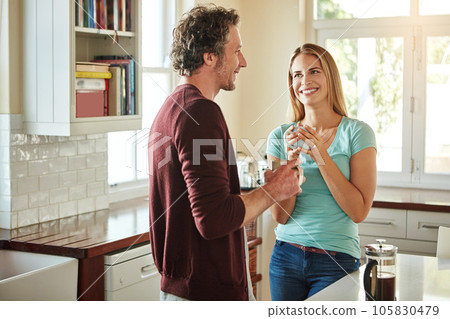Chat, coffee or happy couple speaking in a kitchen at home bonding or enjoying quality morning time together. Funny, smile or mature man talking, relaxing and drinking espresso tea with woman at home 105830479