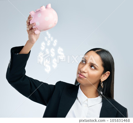 He who loses faith, loses all. a young female holding a piggy bank against a grey background. 105831468
