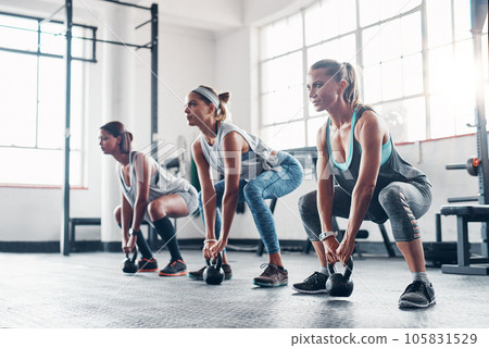Kettlebell, sports and women with fitness, workout and progress with balance, stress relief or wellness. Female athletes, friends or group with gym equipment, goal and exercise with healthy lifestyle Kettlebell, sports and women with fitness, workout and progress with balance, stress relief or wellness. Female athletes, friends or group with gym equipment, goal and exercise with healthy lifestyle 105831529