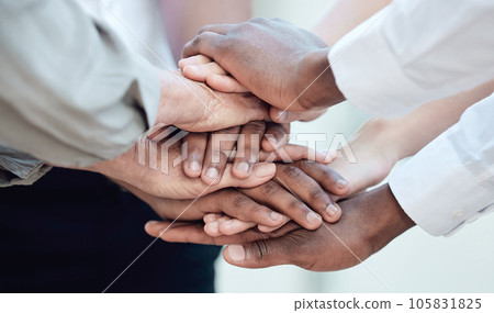 Seldom has anything of greatness been the result of a solo effort. Shot of a group of unrecognizable businesspeople standing with their hands stacked. 105831825
