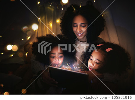 Tablet, night a mother reading to her kids in a tent while camping in the bedroom of their home together. Black family, story or children with a woman storytelling to her kids at bedtime for bonding Tablet, night a mother reading to her kids in a tent while camping in the bedroom of their home together. Black family, story or children with a woman storytelling to her kids at bedtime for bonding 105831916