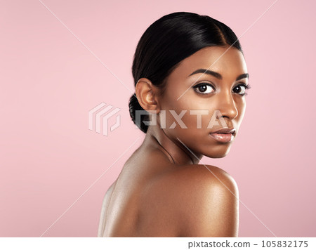 Serious face, skincare and woman in studio isolated on a pink background mockup space. Natural beauty, portrait and Indian female model with makeup, cosmetics or spa facial treatment for healthy skin Serious face, skincare and woman in studio isolated on a pink background mockup space. Natural beauty, portrait and Indian female model with makeup, cosmetics or spa facial treatment for healthy skin 105832175