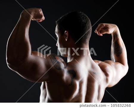 Let me share my strengths with you, itll make you look weak. athletic young man flexing his muscles while posing against a dark background. Let me share my strengths with you, itll make you look weak. athletic young man flexing his muscles while posing against a dark background. 105832268
