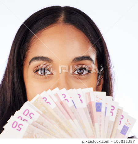 Portrait, cash and a woman lottery winner in studio on a white background in celebration of a bonus or promotion. Eyes, money and finance payment with the face of a young person holding euro notes 105832387
