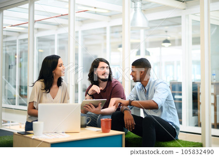 Working together to exceed the expectations of everyone. Shot of a group of businesspeople using a digital tablet together in an office. 105832490
