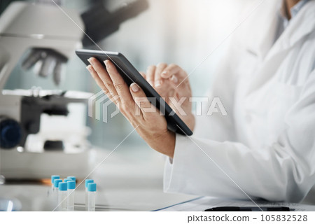 Making a record of her research. Cropped shot of an unrecognizable mature female scientist using a tablet while doing research in her lab. Making a record of her research. Cropped shot of an unrecognizable mature female scientist using a tablet while doing research in her lab. 105832528
