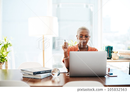 The most effective way to do it is simply to do it. Shot of a young businesswoman wearing earphones while working on a laptop in an office. 105832563