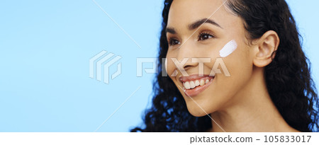 Woman, face and brush cream for skincare, aesthetic salon and beauty on blue background. Happy studio model, facial lotion and makeup cosmetics for dermatology, collagen mask and smile of happiness 105833017