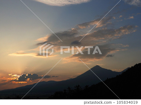 磐梯山山麓的夕陽、山體和橙色雲彩的輪廓以及從雲層射出的放射狀光線令人印象深刻且美麗。 磐梯山山麓的夕陽、山體和橙色雲彩的輪廓以及從雲層射出的放射狀光線令人印象深刻且美麗。 105834019