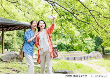 Image of a middle-aged women's trip strolling through a park in a tourist spot 105834225