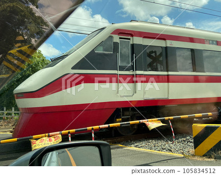 Express train seen from inside a car waiting for a railroad crossing (smartphone photo) 105834512