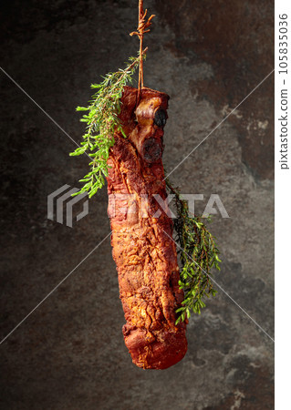 Smoked pork ribs with juniper branches on an old stone background. 105835036