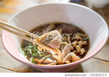 Top view of Duck noodle on a pink bowl with chopsticks on white isolated, focus selective Top view of Duck noodle on a pink bowl with chopsticks on white isolated, focus selective 105835213