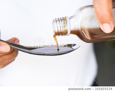 Hand holding Cough Medicine Pour in Spoon close up ,Sick Problem,Medicine in Hospital concept. Hand holding Cough Medicine Pour in Spoon close up ,Sick Problem,Medicine in Hospital concept. 105835514