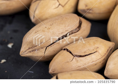 cracked unpeeled pecans close-up on the table cracked unpeeled pecans close-up on the table 105835790