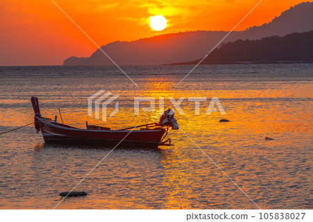 amazing yellow sky of sunrise above the island.  The brilliant yellow hue of the sky created a breathtaking scene as the sun slowly rose over the island. fishing boats parking on the golden sea. 105838027