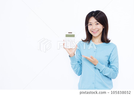 A woman in her thirties with a calculator in front of a white background 105838032