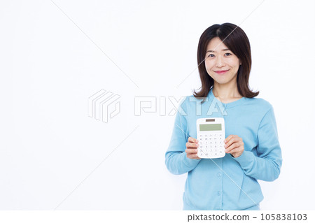 A woman in her thirties with a calculator in front of a white background A woman in her thirties with a calculator in front of a white background 105838103