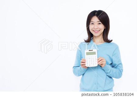 A woman in her thirties with a calculator in front of a white background 105838104