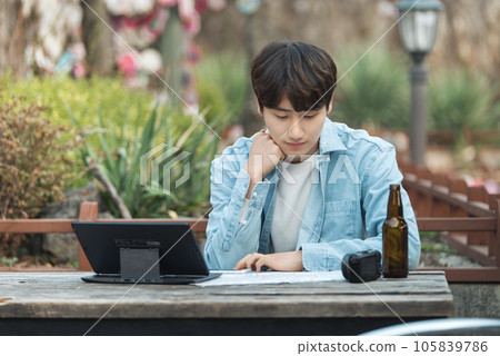 young man with laptop sitting on bench young man with laptop sitting on bench 105839786