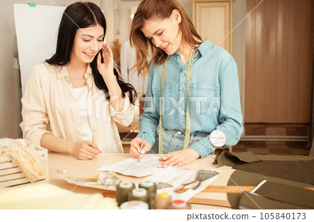 Women seamstresses discuss sketches tailoring ateliers, small businesses, businesswomen entrepreneurship. Beautiful dress. smiling, happy 105840173