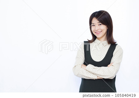 一個三十多歲的女人，雙臂交叉，微笑著思考 105840419
