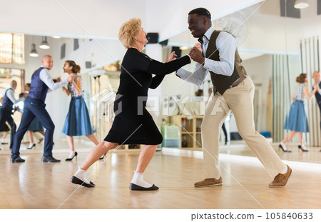 Lady learning to dance lindy hop with man in dance school Lady learning to dance lindy hop with man in dance school 105840633