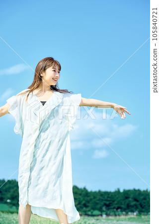 A young woman showing a relaxed expression under the clear sky A young woman showing a relaxed expression under the clear sky 105840721