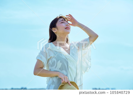 A young woman showing a relaxed expression under the clear sky A young woman showing a relaxed expression under the clear sky 105840729