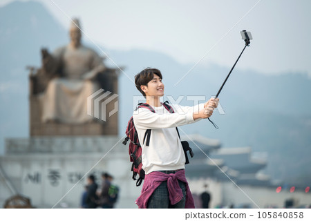 A young man taking pictures with a smartphone camera in Seoul, Korea's representative city 105840858