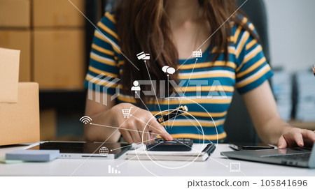 Entrepreneur using calculator in her hand, calculating financial expense at home office, online market packing box delivery,Startup successful small business owner, SME, concept. Entrepreneur using calculator in her hand, calculating financial expense at home office, online market packing box delivery,Startup successful small business owner, SME, concept. 105841696