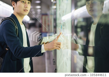 a young man holding a map at a train station 105844611