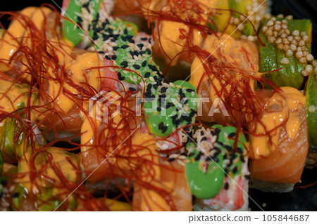 Rolls with red fish, rice, avocado, saffron. Set of rolls in a plate on a white background Rolls with red fish, rice, avocado, saffron. Set of rolls in a plate on a white background 105844687