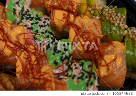 Rolls with red fish, rice, avocado, saffron. Set of rolls in a plate on a white background Rolls with red fish, rice, avocado, saffron. Set of rolls in a plate on a white background 105844688