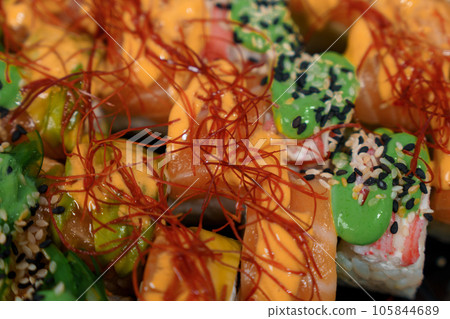 Rolls with red fish, rice, avocado, saffron. Set of rolls in a plate on a white background 105844689