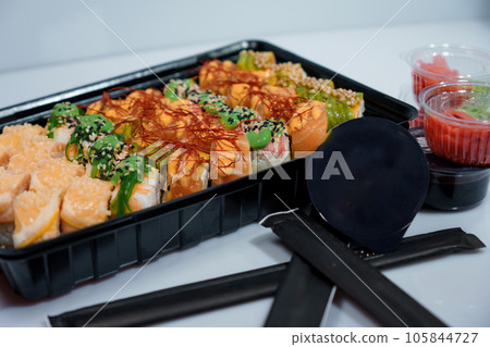 Rolls with red fish, rice, avocado, saffron. Set of rolls in a plate on a white background Rolls with red fish, rice, avocado, saffron. Set of rolls in a plate on a white background 105844727