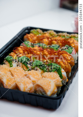 Rolls with red fish, rice, avocado, saffron. Set of rolls in a plate on a white background 105844733