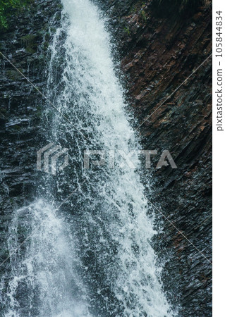 Mountain waterfall, large water flow of mountain waterfall, mountain river near the rock. Huk Waterfall, Ukrainian Carpathians 105844834