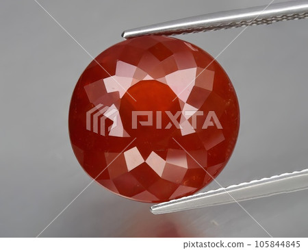 Natural gemstone orange spessartine garnet on gray background Natural gemstone orange spessartine garnet on gray background 105844845