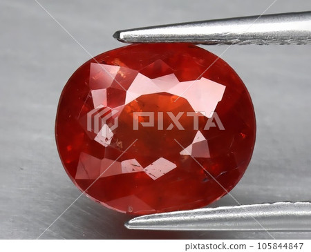 Natural gemstone orange spessartine garnet on gray background Natural gemstone orange spessartine garnet on gray background 105844847