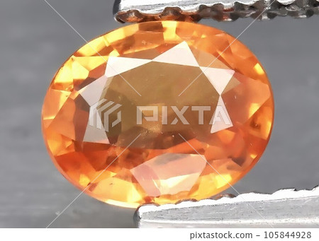 Natural gemstone orange sapphire on gray background 105844928