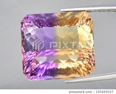 Natural gemstone yellow purple ametrine on a gray background. Purple variety of quartz 105845037