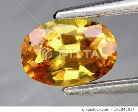 Natural gemstone yellow sapphire on gray background 105845054