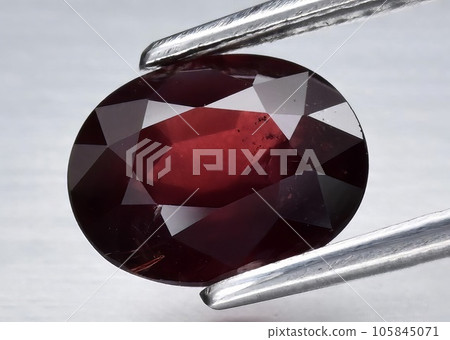 Natural gemstone red rhodolite garnet on gray background Natural gemstone red rhodolite garnet on gray background 105845071