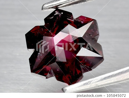 Natural gemstone red rhodolite garnet on gray background Natural gemstone red rhodolite garnet on gray background 105845072