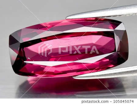 Natural gemstone red rhodolite garnet on gray background Natural gemstone red rhodolite garnet on gray background 105845074